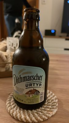 Eine Flasche Dithmarscher Urtyp auf dem Tisch im Huus Marie, eiskalt mit Wasserperlen, einladend