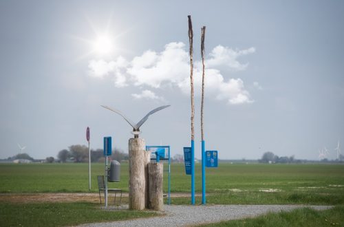 Möwen-Skulptur aus Stahl vor der Siedlung Friedrichskoog Spitze, mystisch mit Wolken und verdeckter Sonne