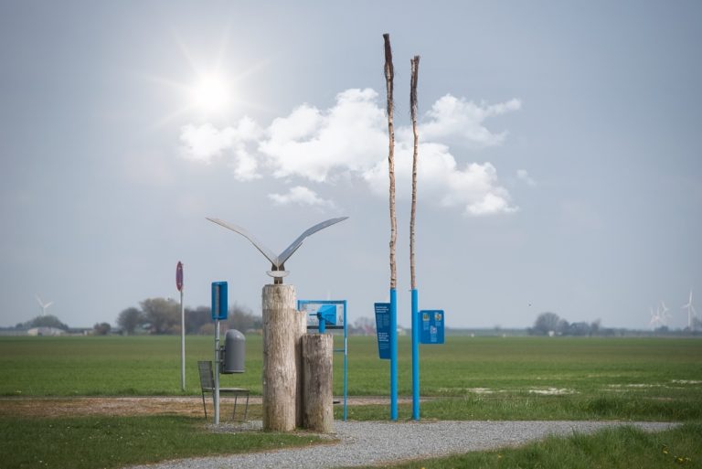 Möwen-Skulptur aus Stahl vor der Siedlung Friedrichskoog Spitze, mystisch mit Wolken und verdeckter Sonne