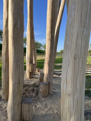 Nahaufnahme von Holzpfählen, die als Tritt-und Geschicklichkeitsspiel auf einem Kinderspielplatz in der Kurparkanlage Friedrichskoog angelegt sind