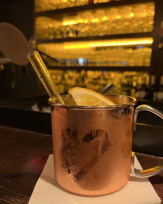 Kalter Cocktail mit Orangenscheibe an einer Bar