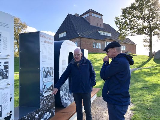Besucher an Informationstafel der Neulandhalle Friedrichskoog zur Geschichte der Landgewinnung